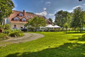 a large house with a grass yard and a driveway at Lieblingsplatz Bohlendorf Rügen in Wiek auf Rügen