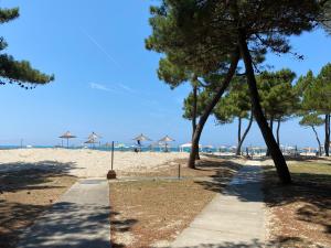 a sidewalk leading to a beach with umbrellas at Pines Paradise at Blue Laguna Residence in Golem