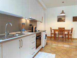 a kitchen with white cabinets and a table with a dining room at Blue Laguna Pines Retreat in Golem +46 photos