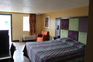 a hotel room with a bed and a chair at Executive Inn & Suites in Nashville