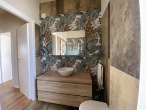 een badkamer met een wastafel en een spiegel aan een muur bij StanzeLatina in Latina