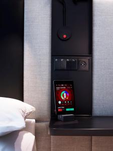 a smart phone sitting on a table next to a bed at citizenM Miami South Beach in Miami Beach