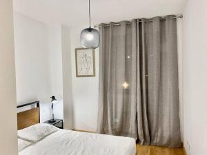 a bedroom with a bed and a window with curtains at Valleca Tren Sierra Guadalupe 2 in Madrid