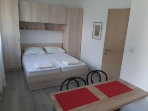 ザオストログにあるApartments Mediciの小さなベッドルーム(ベッド1台、テーブル、椅子付)