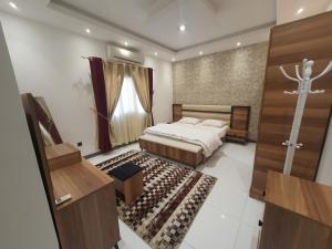 a bedroom with a bed and a door to a room at الخوير هوم in Muscat
