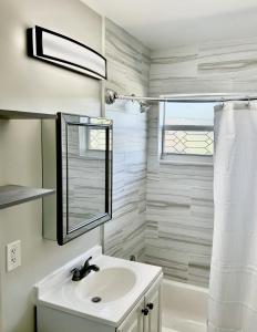 a white bathroom with a sink and a mirror at Perfect location, close to everything! in West Palm Beach +33 photos