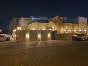 a house with lights on the side of it at night at الخوير هوم in Muscat