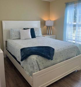 une chambre avec un grand lit blanc avec des oreillers bleus dans l'établissement Horizon Cottage #4, à Rockport