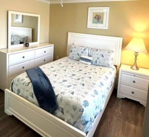 une chambre avec un lit, une commode et un miroir dans l'établissement Horizon Cottage #4, à Rockport