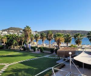 - une vue sur un parc avec des palmiers et l'eau dans l'établissement Hotel Ambrosia, à Bitez