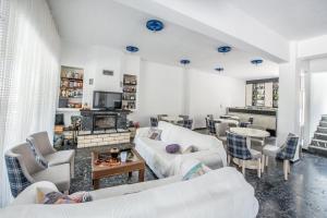 a living room with white furniture and a fireplace at Hotel Dellis in Kamena Vourla