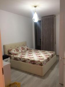 - une chambre avec un lit et une couette à fleurs dans l'établissement one bedroom apartment, à Tirana