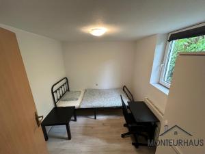 ein kleines Zimmer mit einem Bett, einem Tisch und Stühlen in der Unterkunft Monteurhaus in Unterkirchberg