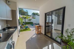 Una cocina con vista a un patio trasero con piscina. en Kamabre Luxury Villas, en Foz do Iguaçu