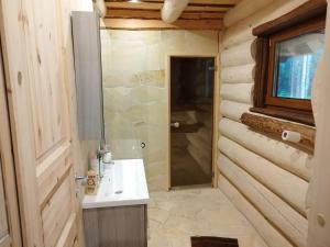 une salle de bain avec un lavabo et une douche dans l'établissement Rooslepa puhkemaja, à Tuksi