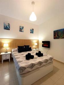 Un dormitorio con una cama grande con dos sillas negras encima. en VUT Bajo Castillo, en La Iruela