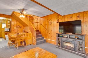ein Wohnzimmer mit einem TV, einem Tisch und einem Kamin in der Unterkunft Cozy Wisconsin Cabin Walk to Beach and Boat Ramp! in McGregor