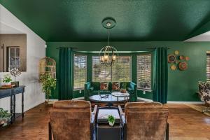 a green living room with a table and chairs at Emerald Ranch of Yosemite in Coarsegold