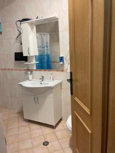ein Badezimmer mit einem Waschbecken, einem Spiegel und einem WC in der Unterkunft Sol Apartments in Tirana