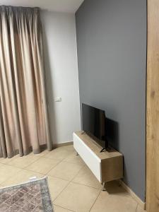 een woonkamer met een flatscreen-tv op een standaard bij Sol Apartments in Tirana