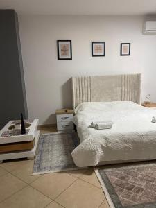 ein Schlafzimmer mit einem weißen Bett und einem Tisch in der Unterkunft Sol Apartments in Tirana