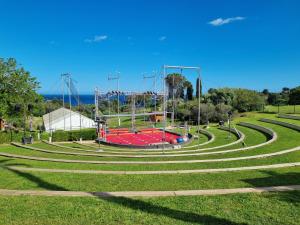 un parc vide avec une aire de jeux dans l'herbe dans l'établissement CAP ESTEREL AGAY SAINT RAPHAEL VUE MER Studio 4 personnes chez Evelyne, à Saint-Raphaël