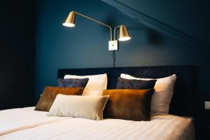 ein blaues Schlafzimmer mit einem Bett mit Kissen in der Unterkunft Hotel Renesse in Renesse