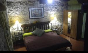 una camera con un letto in una parete in pietra di Posada del Dulce Sueño a Mojares