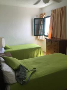 1 dormitorio con 2 camas verdes y vestidor en Lanzarote Club Tahiti - July 11, 2024 until July 17, 2024 en Costa Teguise