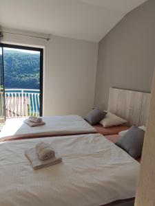 a bedroom with two beds and a large window at Villa Luma Apartments in Labin