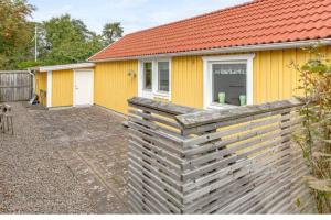 una casa amarilla con una valla delante de ella en Tylösand guesthouse 300m from ocean & golf course, en Halmstad