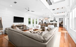 Una sala de estar con un sofá y un televisor. en La Pura Vida, en Inlet Beach