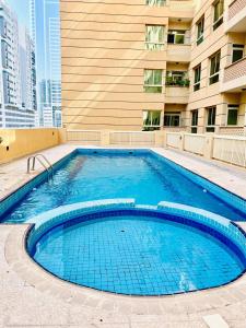 una grande piscina di fronte a un edificio di Cozy 2 Bedroom Apartment in Al Nahda Dubai a Dubai