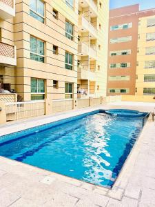 una piscina di fronte a un edificio di Cozy 2 Bedroom Apartment in Al Nahda Dubai a Dubai