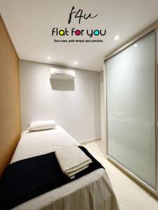 een kamer met een bed en een bord dat voor je griepgevecht leest bij 1501B - Espaçoso apê 2Q St Bueno in Goiânia