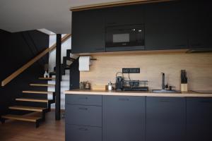 a kitchen with a counter top and a staircase at Woodpecker in Nagymaros