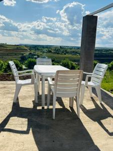 una mesa blanca y sillas en un patio con vistas en The Farmhouse 