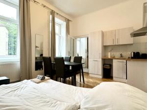 a bedroom with a bed and a table and chairs at Cosy Apartment located at famous Vienna Kutschkermarkt in Vienna
