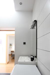 een witte badkamer met een wastafel in een kamer bij Casa da Viola - Faro in Faro