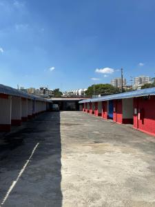 een lege parkeerplaats met rode en witte gebouwen bij Motel Power in Belo Horizonte