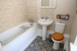 a bathroom with a toilet and a sink and a tub at Hen Blas, 14th century 2 bedroom Cottage in Barmouth +13 photos