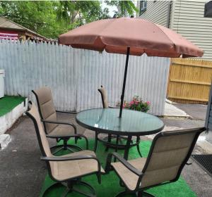 einen Tisch mit Stühlen und einem Sonnenschirm auf einer Terrasse in der Unterkunft Homely 3 Bedroom unit in Newark
