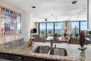 a kitchen with a sink and a living room at One Seagrove Place 0506 in Seagrove Beach