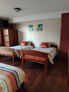 - une chambre avec 2 lits et un banc dans l'établissement Hotel Pegasus, à Cuenca