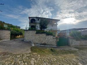 una casa con una pared de piedra y un edificio en Guest House Irvin, en Berat