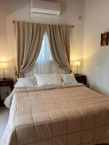 a large bed in a bedroom with a window at Entre Sierras VGB Bertone in Villa General Belgrano