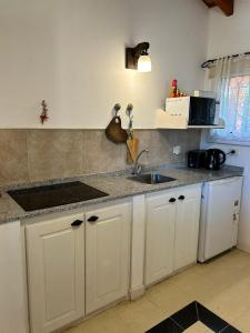 a kitchen with a sink and a counter top at Entre Sierras VGB Bertone in Villa General Belgrano