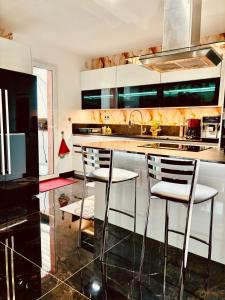 uma cozinha com duas cadeiras e uma bancada em Superbe Villa avec piscine - vue mer - Presqu'Île de Giens - 5 étoiles em Hyères