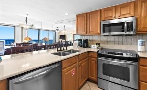 a kitchen with stainless steel appliances and a dining room at One Seagrove Place 1606 in Santa Rosa Beach