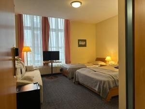 ein Hotelzimmer mit 2 Betten und einem TV in der Unterkunft Self Check-in Hotel Am Schottenpoint in Wien